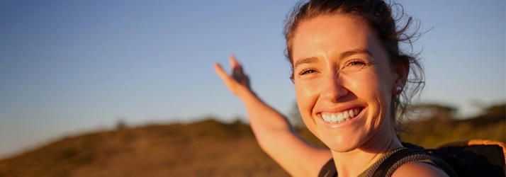 A happy woman outside hiking.
