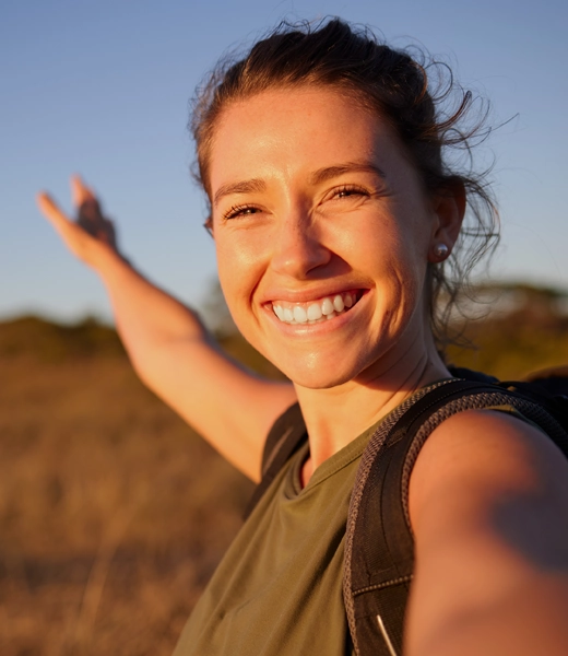 A blonde haired woman outside smiling.